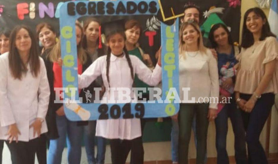 La alumna Valentina Marisol Aguirre junto al personal docente en su acto de egreso de séptimo grado