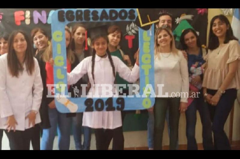 La alumna Valentina Marisol Aguirre junto al personal docente en su acto de egreso de séptimo grado